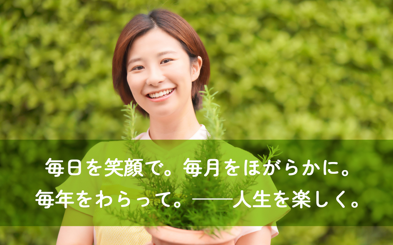 エプロンを付けた笑顔の女性 花笑み3番館のモットーが書いてある